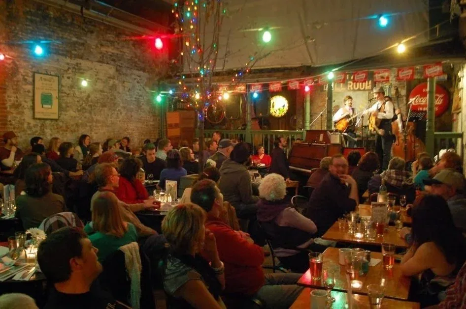 Crowd watching live music under string lights at Arnold's