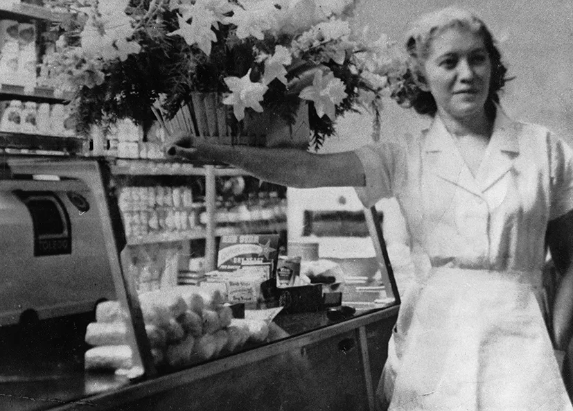 Historic photo of Rose Kravitz beside the deli case