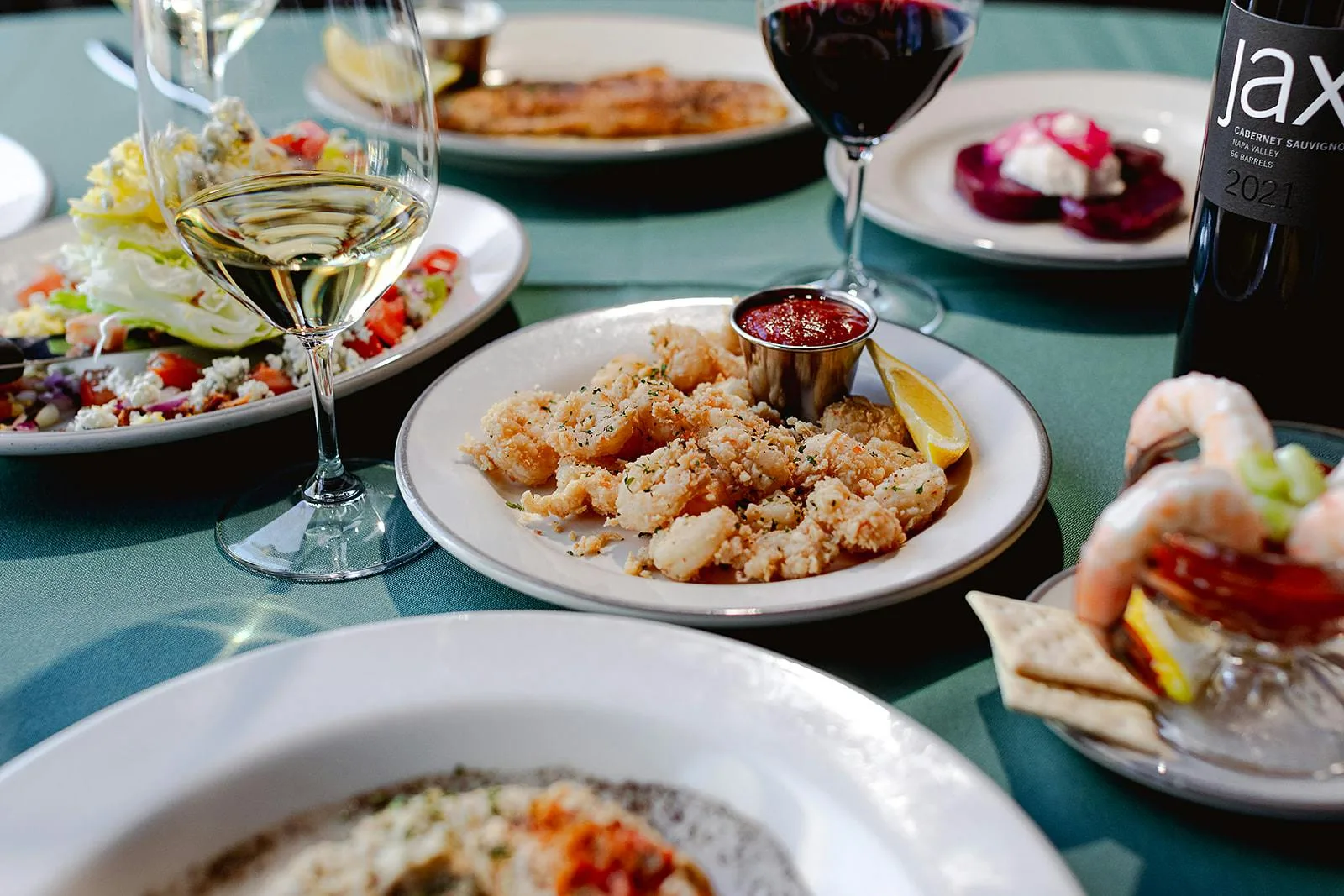 Table of seafood dishes, fries and wine