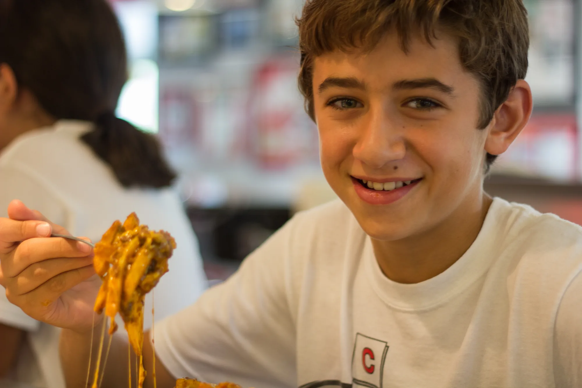 Young diner eating a plate of Cincinnati chili spaghetti