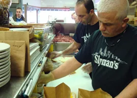 Slyman's staff preparing orders behind the counter