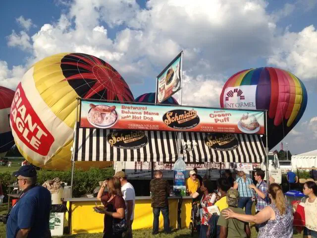 Schmidt's food truck at an outdoor event with hot air balloons